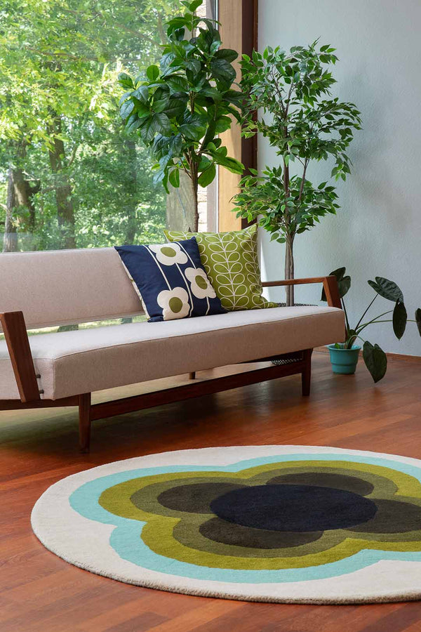 The Orla Kiely round sunflower rug in beautiful olive green shades, seen in a retro-styled living room