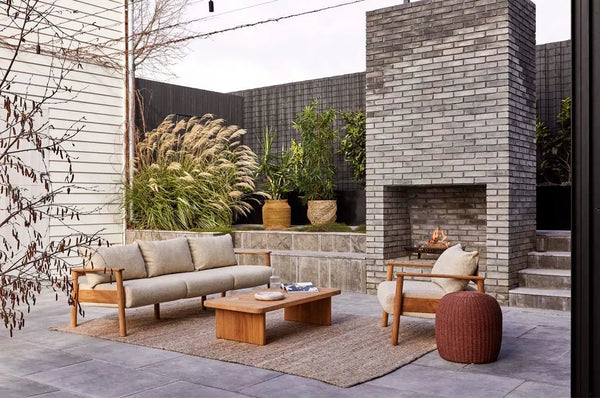A stylish outdoor seating arrangement featuring the Harbour Knot outdoor rug in a tawny brown
