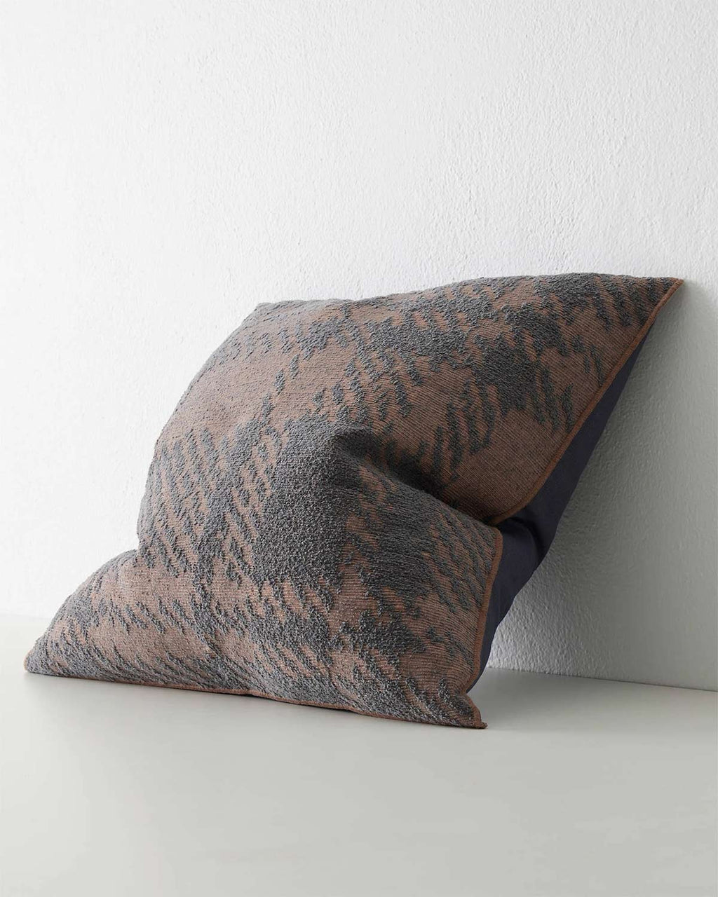 A side view of a dusky purple textural patterned cushion. 