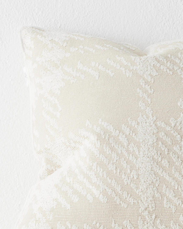 A close up image of a textural check patterned cushion in neutral shades of cream. 