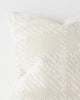 A close up image of a textural check patterned cushion in neutral shades of cream. 