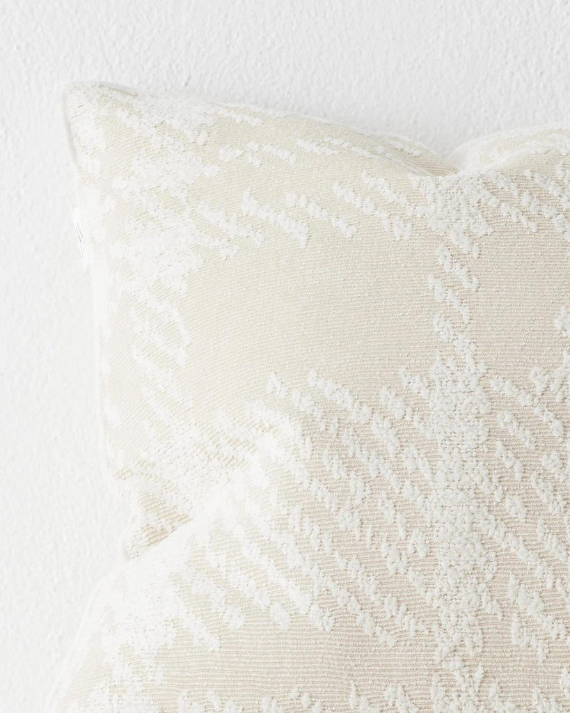 A close up image of a textural check patterned cushion in neutral shades of cream. 