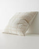 A side view of a light beige and cream cushion with a textured oversize check pattern.