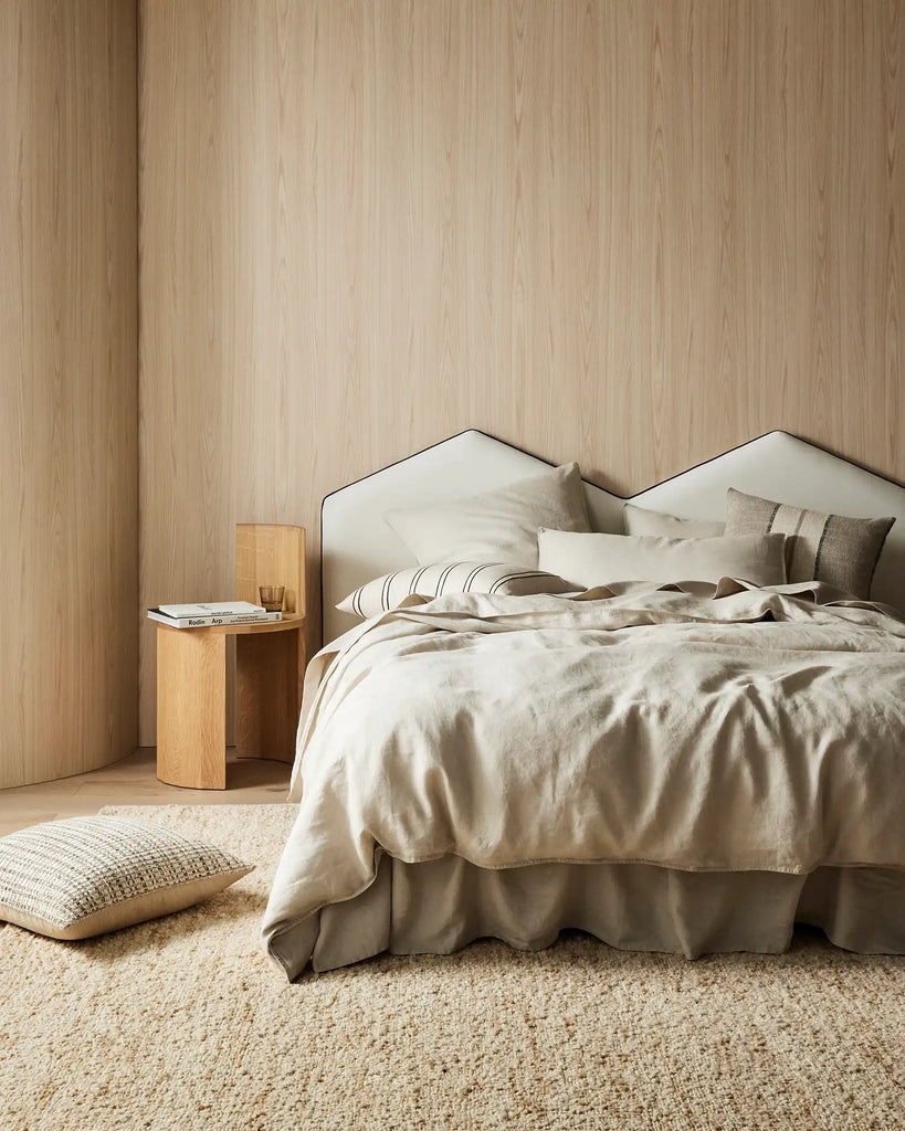 A beautiful, neutral bedroom featuring Weave Home Ravello linen bedding and designer cushions