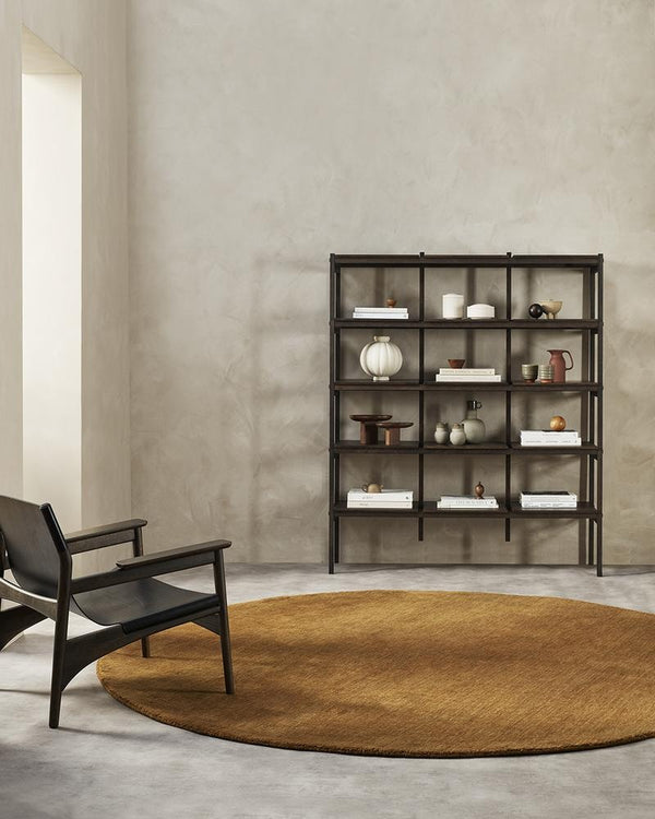 A modern style sitting area with a rich warm brown round floor rug made with 100% wool in the centre of the room. 