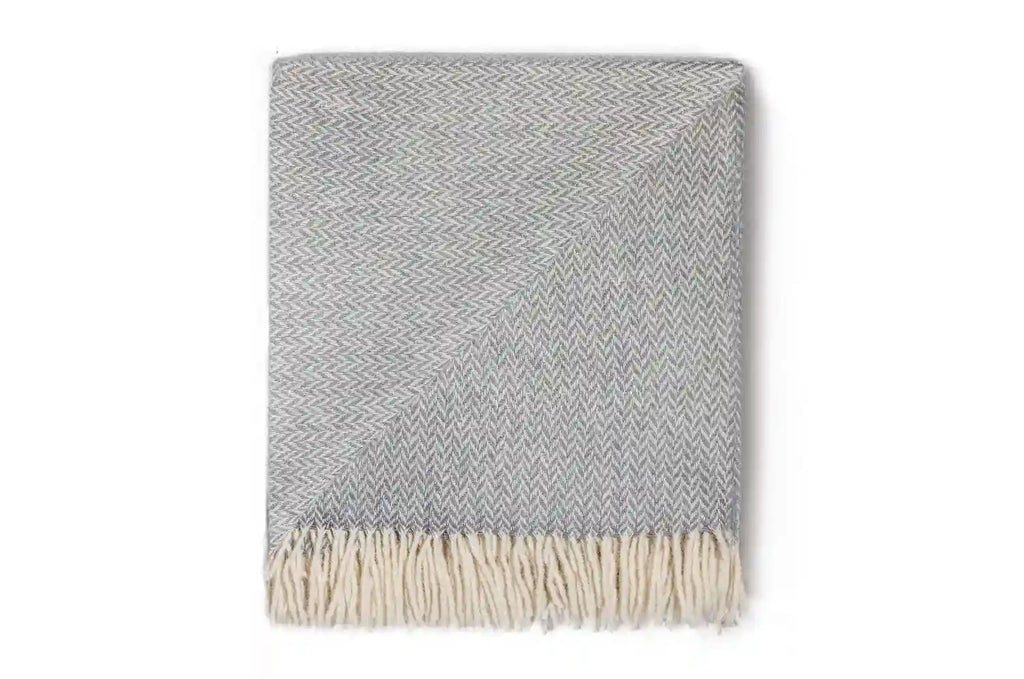 A soft, neutral grey wool throw, by Ruanui Station, in a pretty chevron pattern, 100% nz made