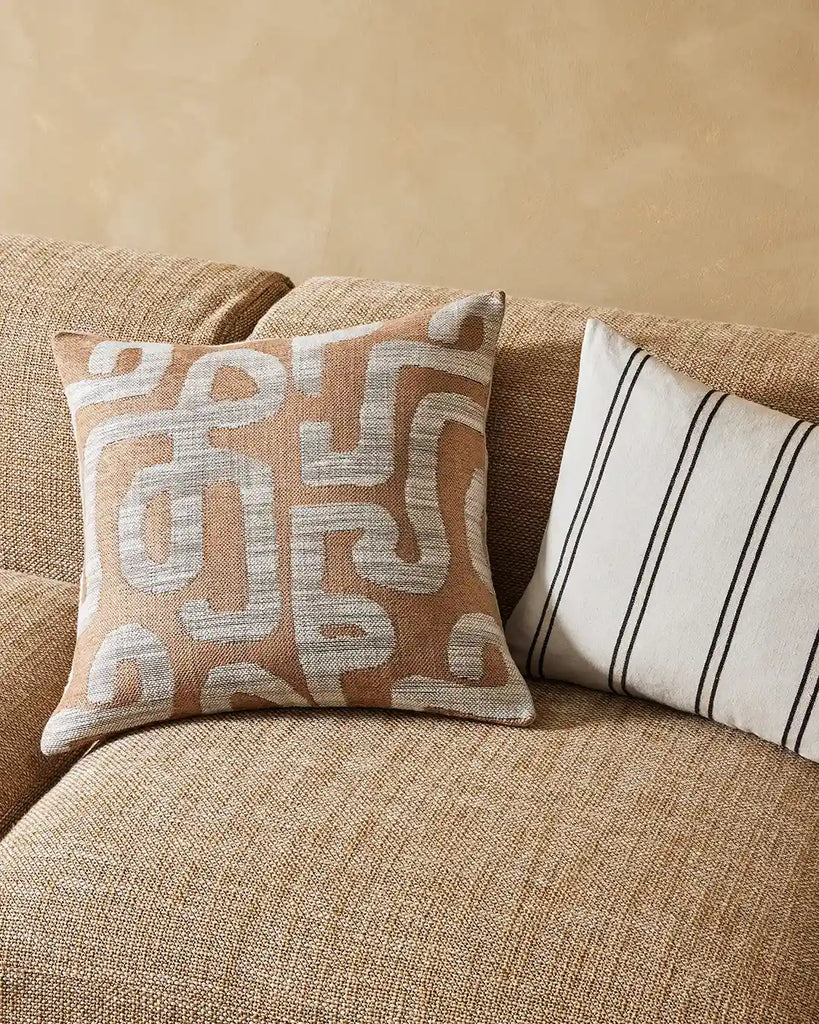 Weave Home Serence Earth designer cushion in an Ikat weave in earthy brown clay tones seen on a couch