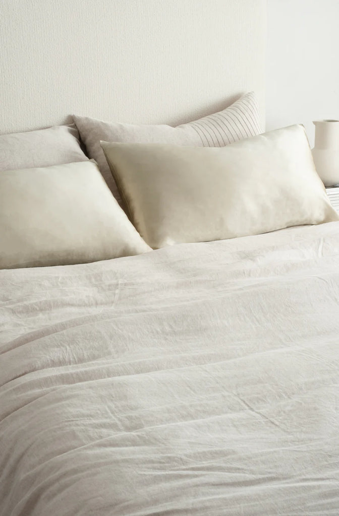 Beautiful silk pillowcase in champagne colour, on a made bed, by Bianca Lorenne