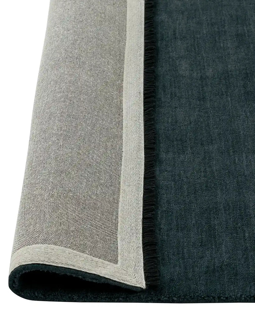 The Weave Home Silvio Rug in colour dusk with the corner folded to reveal underneath