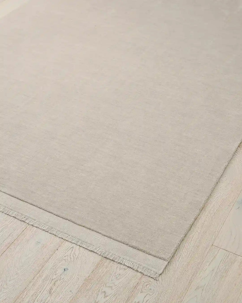 The Silvio wool floor rug in a neutral creamy ecru colour, seen from above