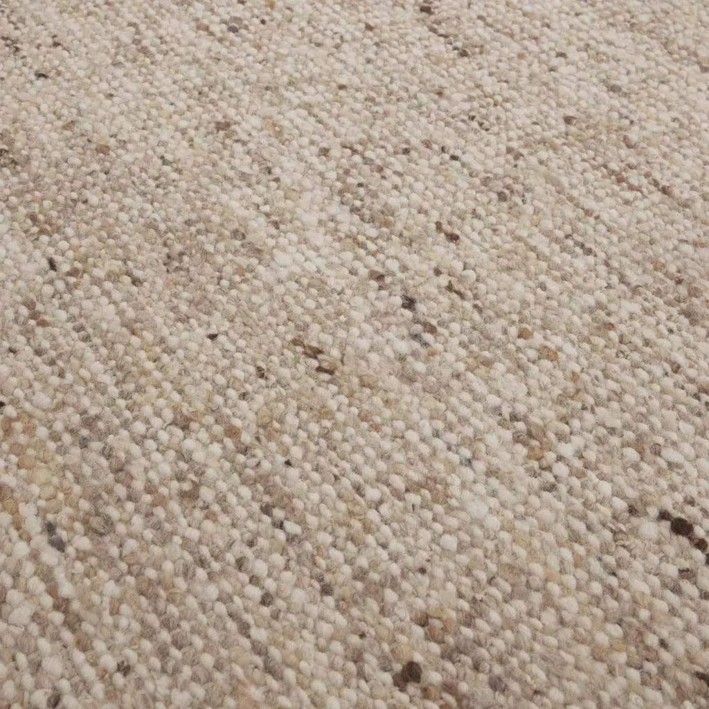 Close up of the weave of a textural woolen rug, in shades of cream, honey brown and light beige, with subtle colour shifts by Soren Liv NZ and Globe West. 