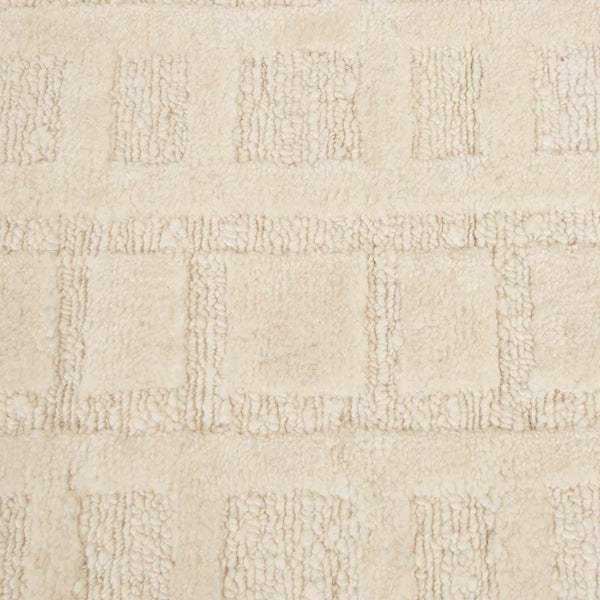 A creamy white wool-blend floor rug featuring an abstract horizontal pattern