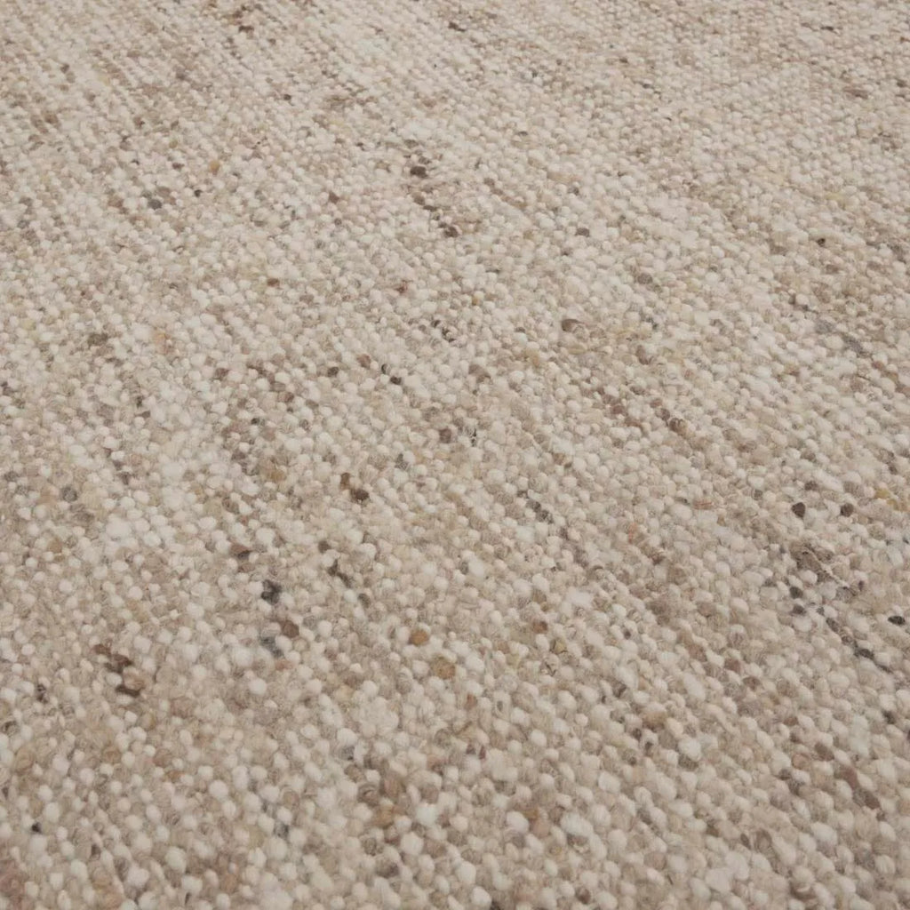 Close up of the weave of a textural woolen rug, in shades of cream, honey brown and light beige, with subtle colour shifts by Soren Liv NZ and Globe West. 