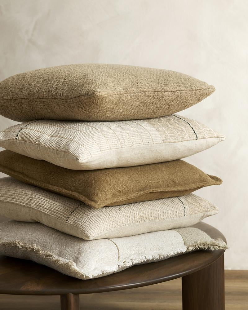 Stack of cream, brown and white cushions in linen and cotton, by Baya NZ.