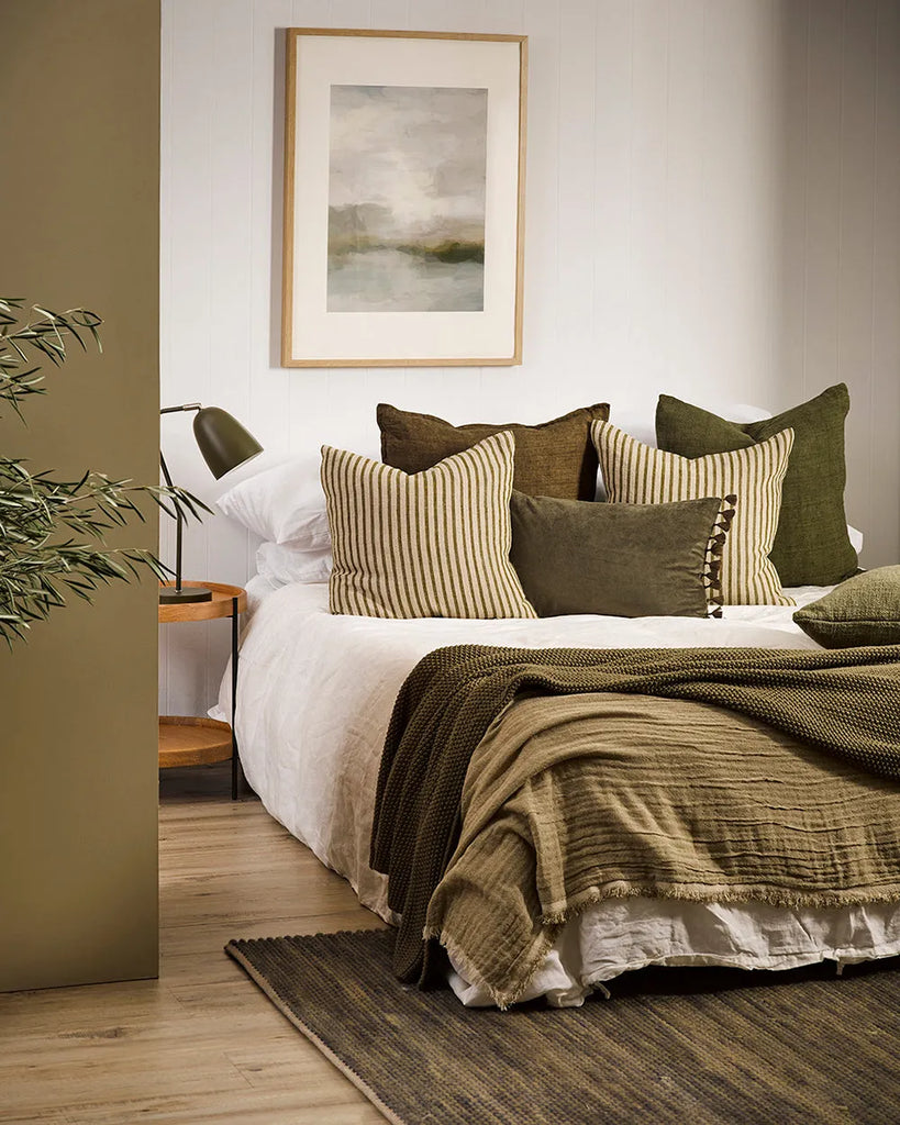 A contemporary bedroom featuring the striped linen Spencer cushion in khaki green