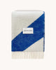 A folded throw made with NZ wool in shades of bright blue and white, by Maison Deux