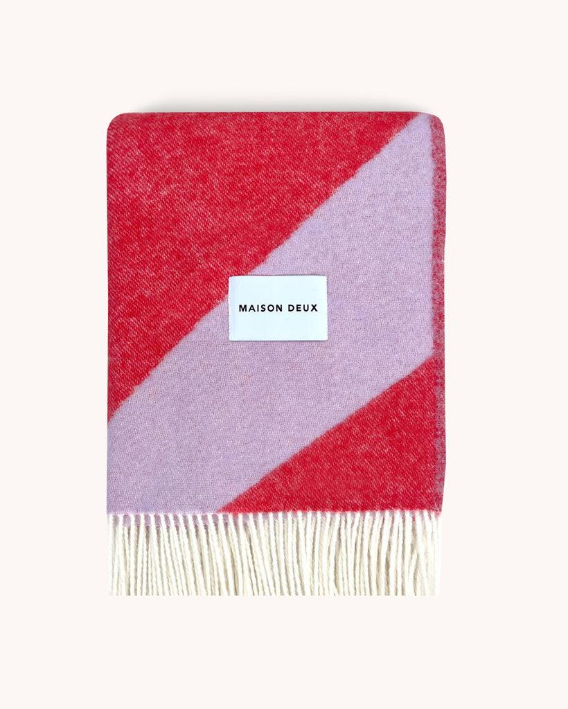 A folded NZ wool throw in vibrant colours of scarlet and lilac by Maison Deux