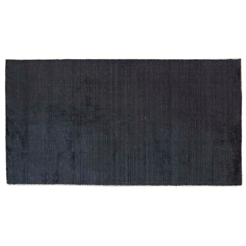 Full view from above of a dark blue wool blend floor rug by Globe West and Soren Liv