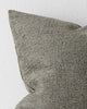 A close up image of a muted moss green cushion with soft elements of texture within the weave. 