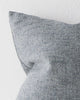 A close up image of a muted blue cushion with a soft textural element within the weave. 