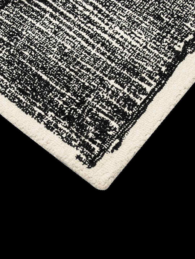 The corner of the black and white Elio 100% wool rug by Tribe Home, shown from above