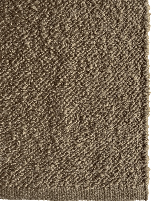Close up of the Tribe Home Finn boucle outdoor rug in silt brown colour