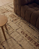 Close view of the Tribe Home Rama wool and jute rug in Cinnamon beside a sofa and side table