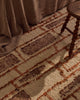 Close view of the Tribe Home Rama wool and jute rug in Sienna at the foot of a bed