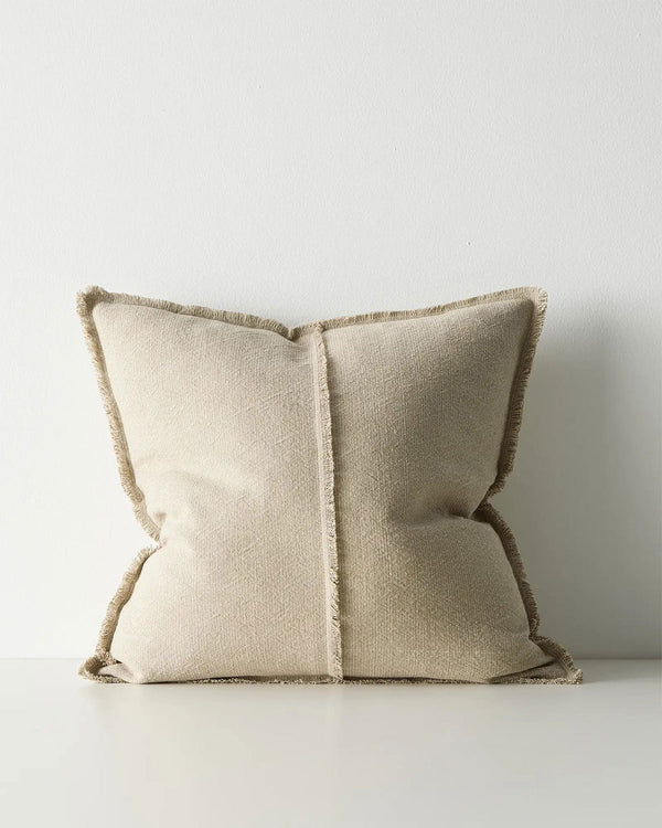 Beige pillow with textured trim on a light background