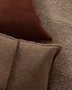 Close-up of two brown textured pillows on a textured surface.
