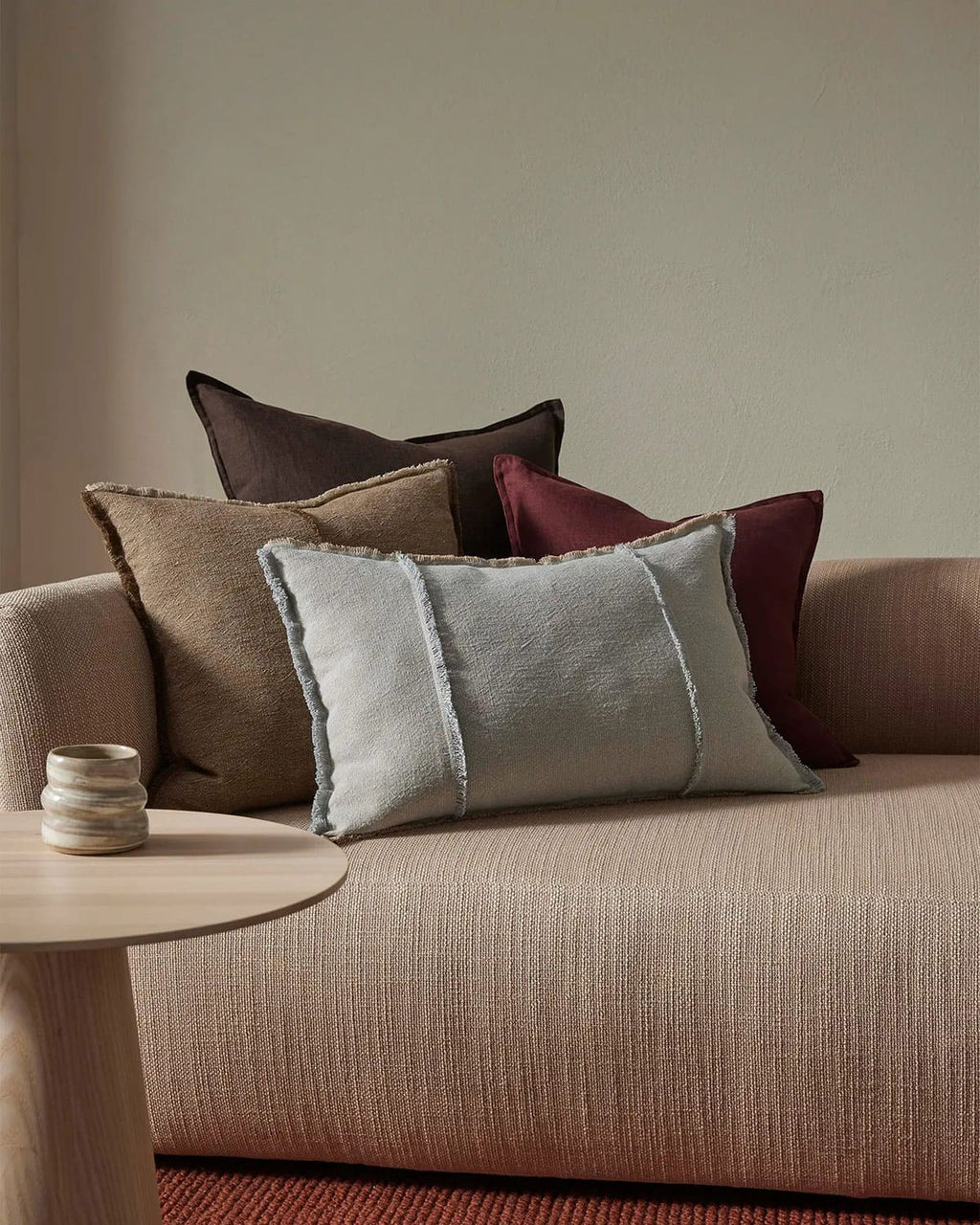 Sofa with decorative pillows and a small table in a living room setting