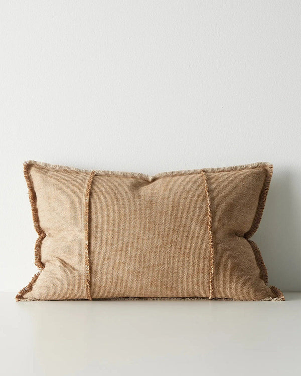 Warm beige cushion with textured edges on a light gray background