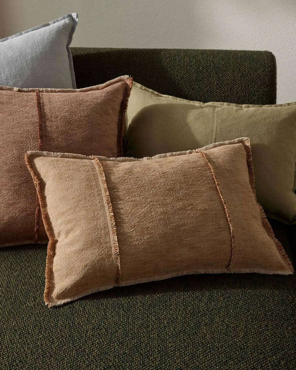 Textured cushions on a green sofa