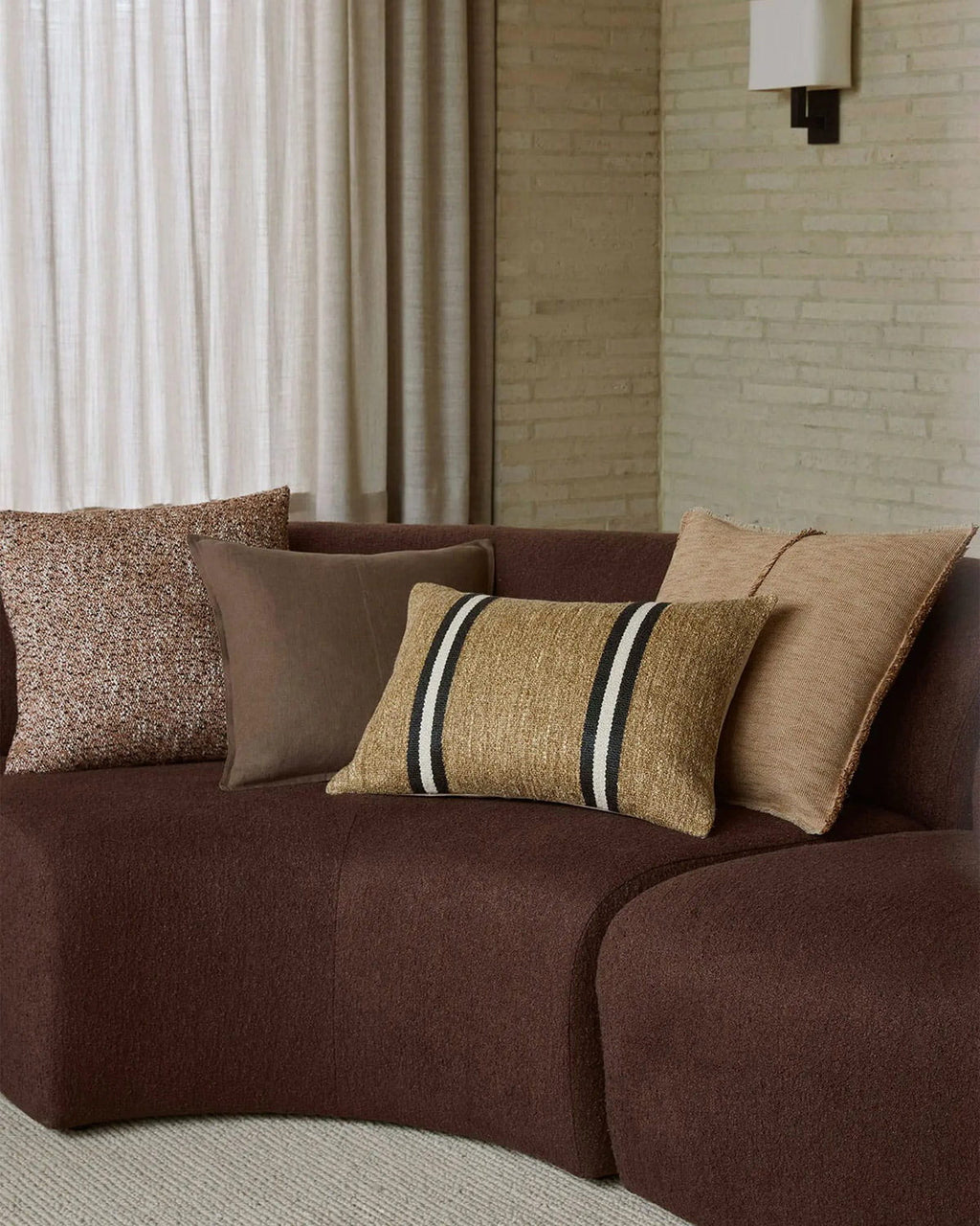 Brown sofa with decorative pillows in a living room setting