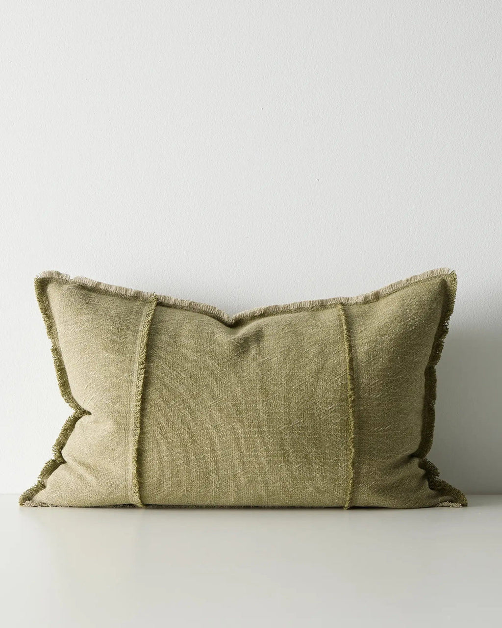 Green lumbar cushion with textured edges on a white background