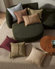 Green modular sofa with colorful cushions on a beige carpet