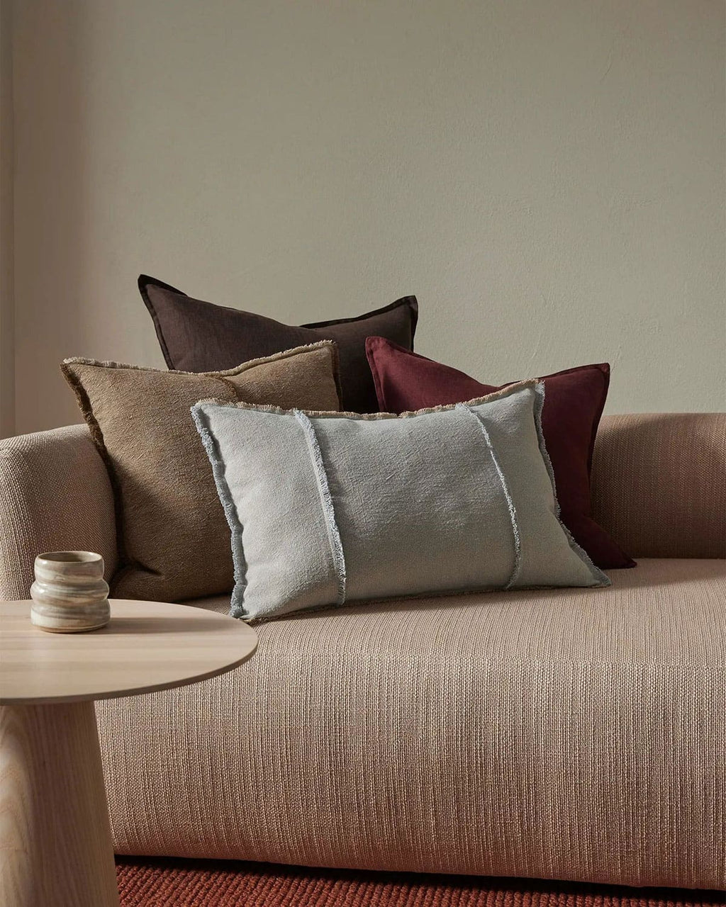 Sofa with decorative pillows and a small table in a room setting