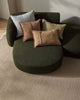 Green modular sofa with colorful cushions on a neutral background