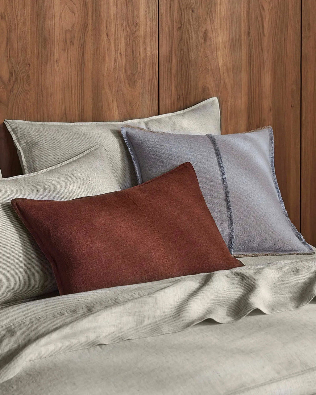 Set of pillows in brown, gray, and beige on a wooden background