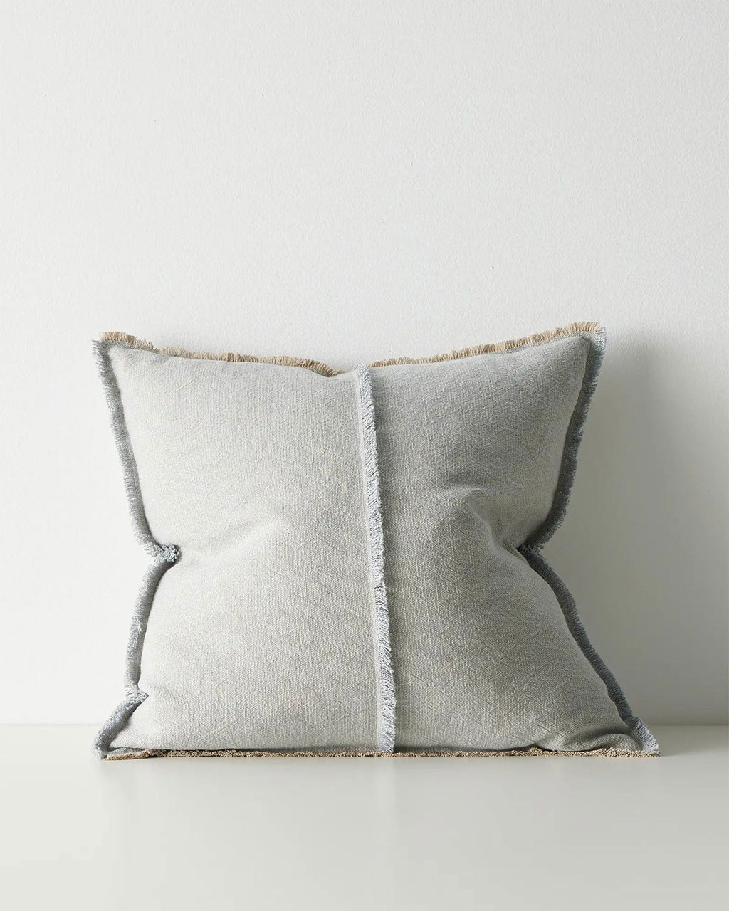 Gray pillow with textured trim on a light gray background