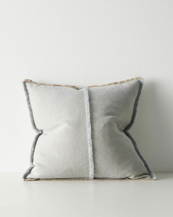 Gray pillow with textured trim on a light gray background