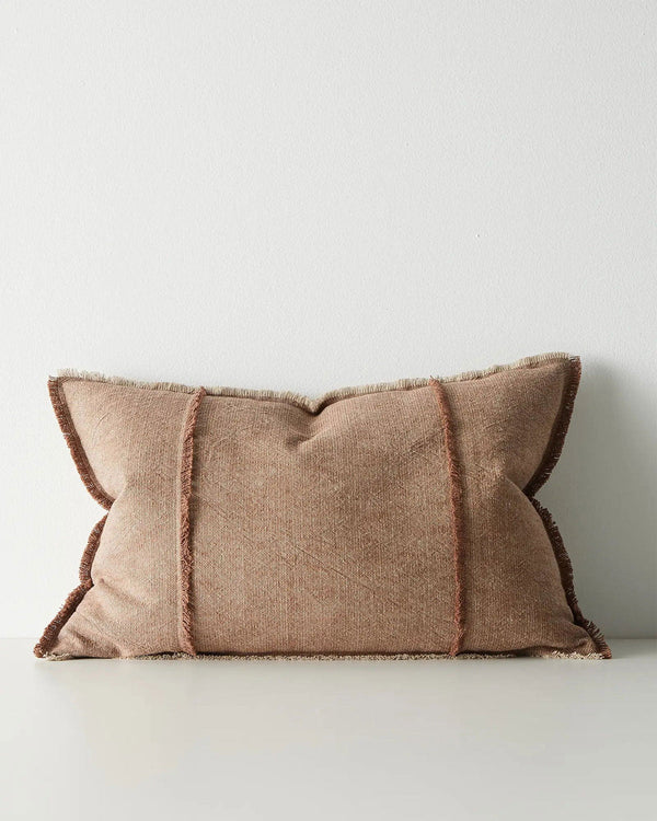 Red-brown lumbar cushion with frayed edges on a white background
