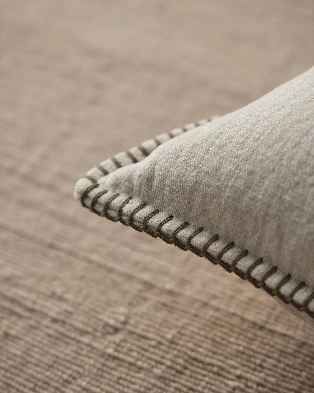 Close up of the brown stitch detail of the beige Alba neutral cushion by Weave