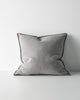 Grey textured cushion with a dark brown stitch detail on a light grey background