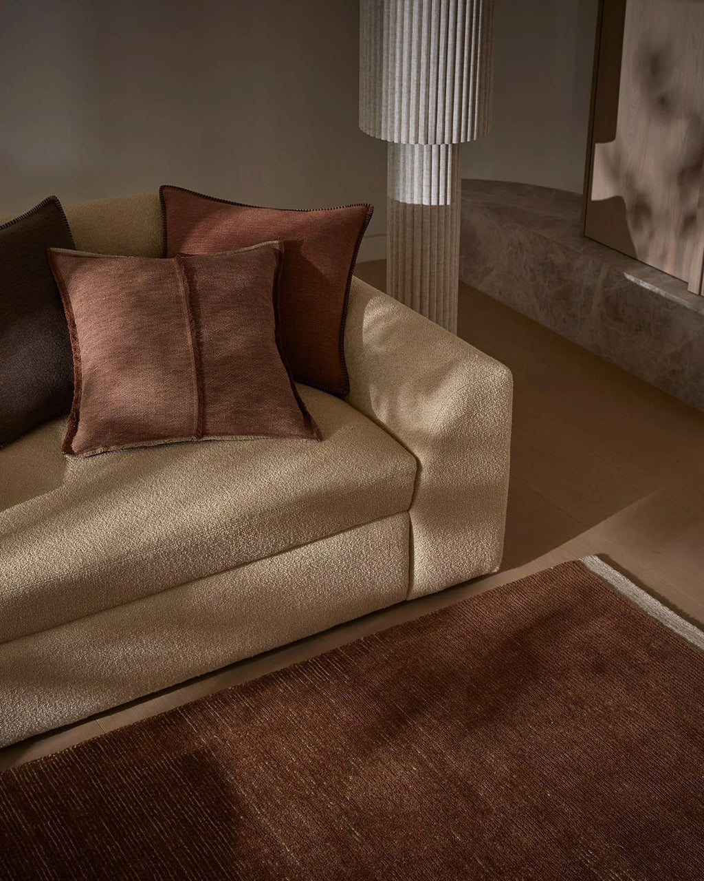 Beige sofa with brown cushions, by Weave Home, in a living room setting