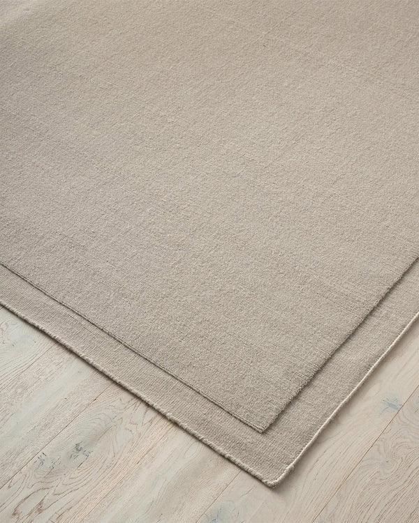 A NZ wool Beige rug by Weave Home on a wooden floor