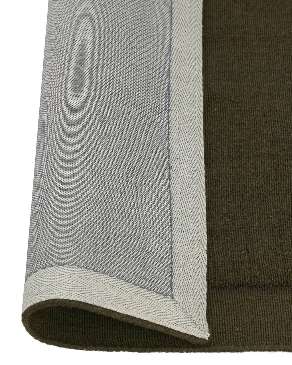 Close up of the Cassio Jasper NZ wool floor rug in a deep olive shade with edge rolled to show backing