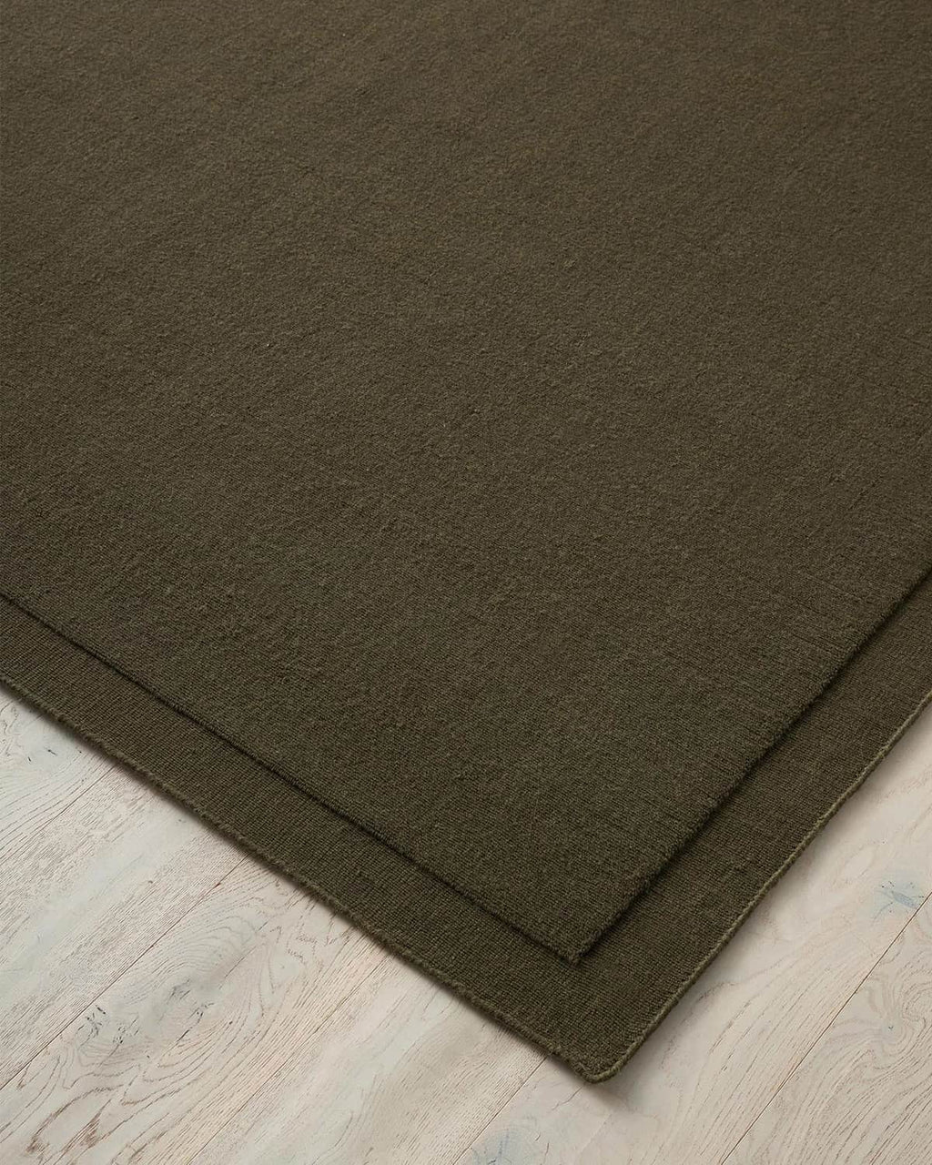 Close up corner of the Cassio Jasper NZ wool floor rug in a deep olive shade 