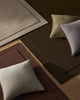 Three NZ wool rugs in beige, chocolate brown and burgundy with a scatter of designer cushions