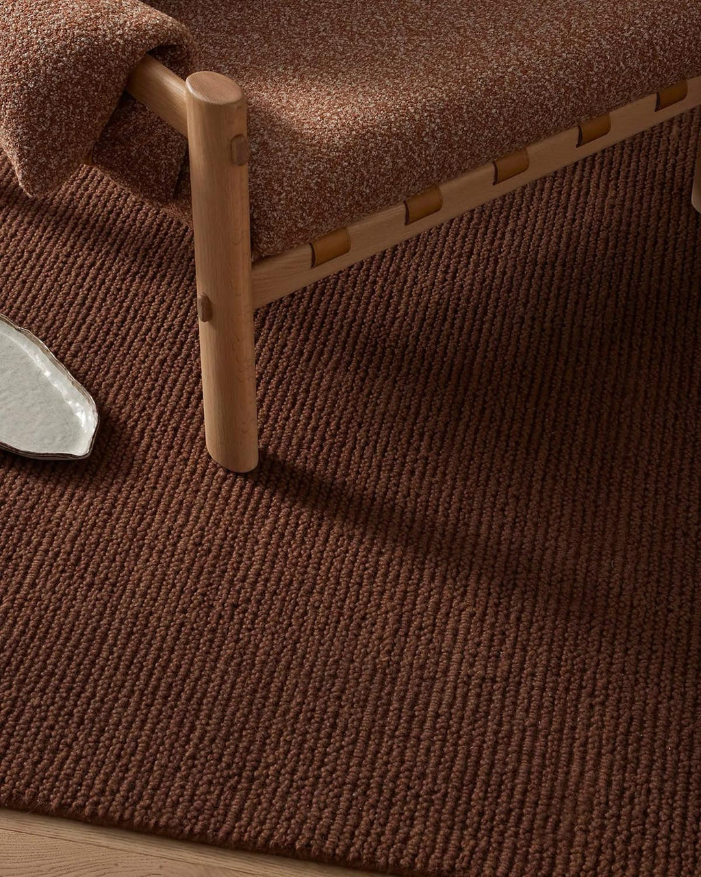 Warm brown textured rug with a wooden chair 